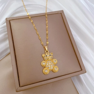 Detailed macro of gold bear pendant encrusted with diamonds on brown jewelry box