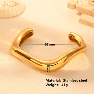 Minimalist gold wave design open bangle in stainless steel on aesthetic textured background