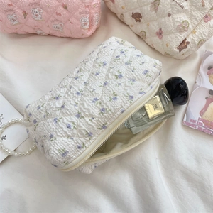Quilted floral makeup bag with metal zipper and soft cotton padding detail view
