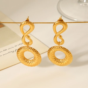 Gros plan de boucles d'oreilles serpent en acier doré 18 carats à texture losange