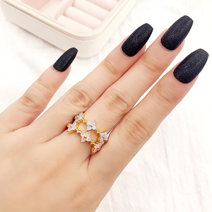 Detailed view of a gold flower ring with blue and purple opal stones worn on finger