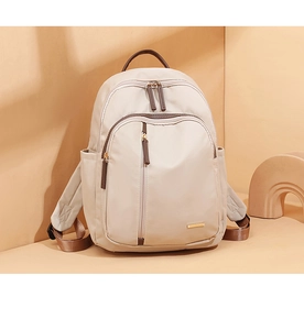 Vista frontal de mochila beige de tela Oxford con correas marrones y detalle de cremallera