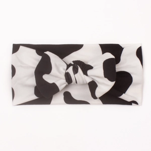 Detail of soft black and white cow print baby headband with a wide-brimmed bow knot