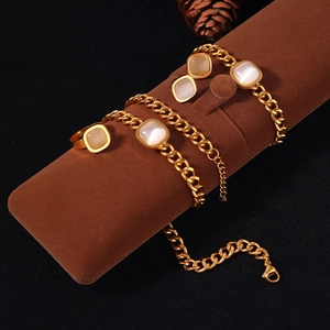 Détail de l'ensemble bijoux chaîne cubaine dorée avec pierres œil de chat sur velours brun