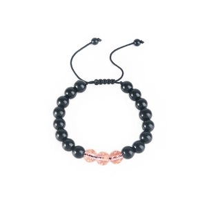 Adjustable beaded bracelet with black rounds and pink gold foil accents in detail view