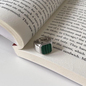 Macro shot of 925 silver ring with rectangular malachite on vintage book pages