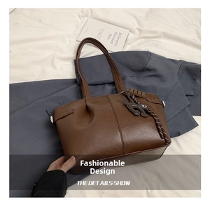 Detailed view of dark brown lychee textured leather tote bag with a cute cat pendant