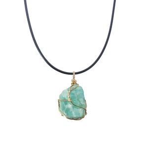 Irregular raw teal crystal pendant wrapped in gold wire with a black cord necklace