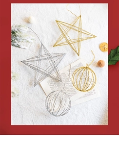 Detail showing gold and silver glittery wire star and ball ornaments on a plush background