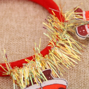 Détail du serre-tête de Noël en velours rouge avec guirlande dorée et éléments festifs