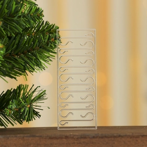 Detail of transparent S-shaped Christmas ornament hooks on a wooden surface with bokeh background