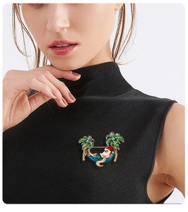 Detail of model wearing Santa Claus in hammock palm tree brooch with colorful enamel