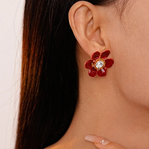 Macro detail of vintage red flower earring with crystal on model's earlobe