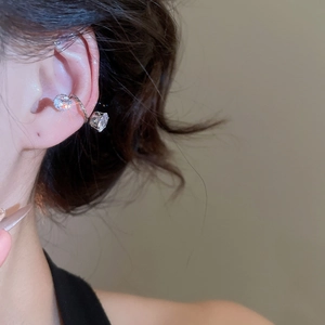 Detail of silver ear cuff set with two clear cubic zirconia on a model ear