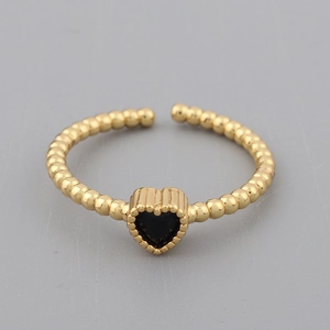Macro top view of gold-plated open heart ring with black stone and beaded texture