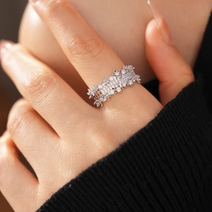 Close-up of wide silver ring with sparkling zircon pavé setting on a hand