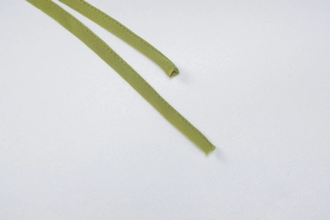 Detail of green ruffle trim lace-up straps on a sheer long sleeve top for women
