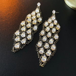 Detailed macro view of golden tassel earrings with sparkling drop-shaped zircon crystals