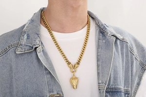 Close-up of a gold punk wolf head pendant with thick Cuban link chain on male model