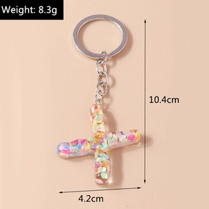 Close-up of resin letter X keychain with colorful sequins and silver metal ring