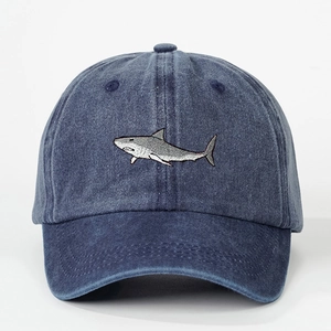 Washed navy blue denim baseball cap with detailed shark embroidery and adjustable fit