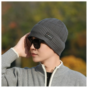 Detail of gray knitted beanie with ribbed texture and FARDI brand label on a male model