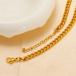 Macro detail of gold-plated stainless steel woven chain with lobster clasp and extender