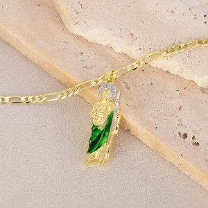 Macro shot of gold St. Jude religious pendant with green and silver details on stone