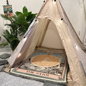 Detail of bohemian tarot The Star woven blanket with tassels inside an indoor camping tent