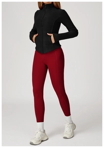 Detail of a black fleece jacket and red high-waisted leggings with side pockets