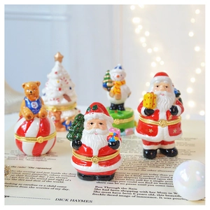 Festive ceramic Christmas trinket boxes on vintage paper with warm bokeh lighting