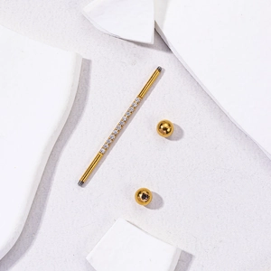 Golden industrial barbell earring in stainless steel with sparkling zirconia stones