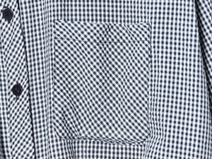 Detailed close-up of gingham pattern shirt featuring breast pocket and black buttons