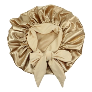 Detail of champagne satin sleep bonnet with adjustable ribbon tie and elastic edge