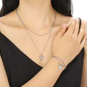 Silver double-layer heart pendant necklace and bracelet set shown on model
