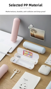 Top view of cylindrical matte PP pencil cases in pastel colors on a wooden desk