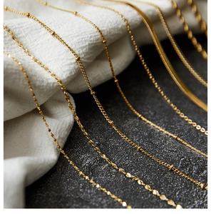 Detailed close-up of multiple 18K gold plated stainless steel necklace chain styles