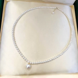 Detail of s925 silver necklace with white freshwater pearls in a gold satin jewelry box