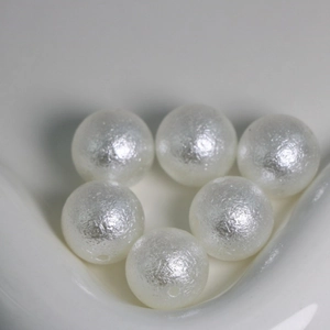 Detailed macro view of white ABS crackle texture beads for DIY jewelry making