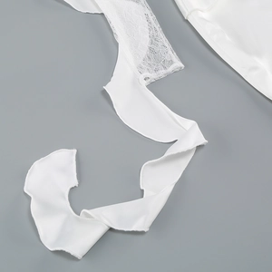 Close-up of white lace and satin fabric with delicate ruffle edge detailing