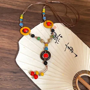 Ethnic handmade ceramic bead necklace with colorful woven rings and vintage tassel pendant