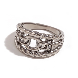 Silver wide band ring with twisted texture and crystal accent on white background