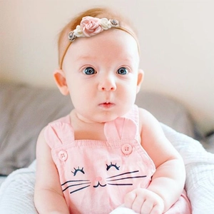Detailed view of infant headband with pink and white fabric roses on baby girl