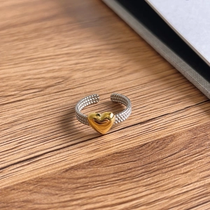 Detailed close-up of S925 sterling silver twisted band ring with golden heart detail