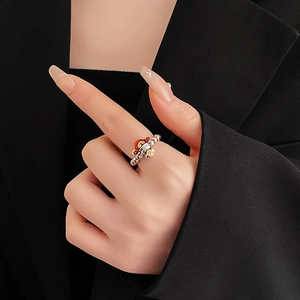 Detailed view of silver beaded ring with colorful dragon-style enamel charms on a model