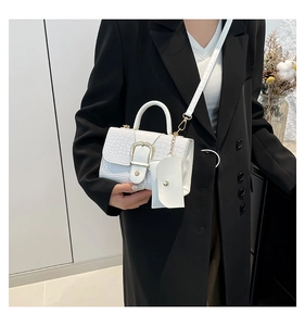 Détail du sac à bandoulière blanc à motif crocodile avec boucle dorée et porte-monnaie