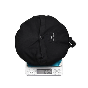Detailed view of 65.2g lightweight packable bucket hat on a scale for portability display