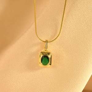 Detail of luxury emerald necklace pendant with white zircon on champagne silk background