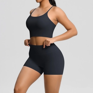 Detail showing the high elasticity of the black sports bra and high-waisted shorts set