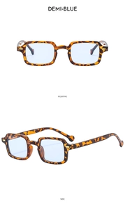 Detail view of square tortoiseshell sunglasses with light blue lenses and silver hardware